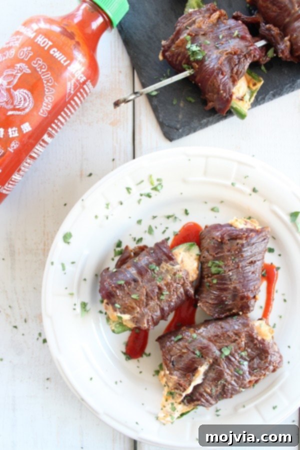 Smoky Sriracha Steak Popper Skewers 2 Sriracha Steak Wrapped Jalapeño Poppers on skewers, grilled to perfection