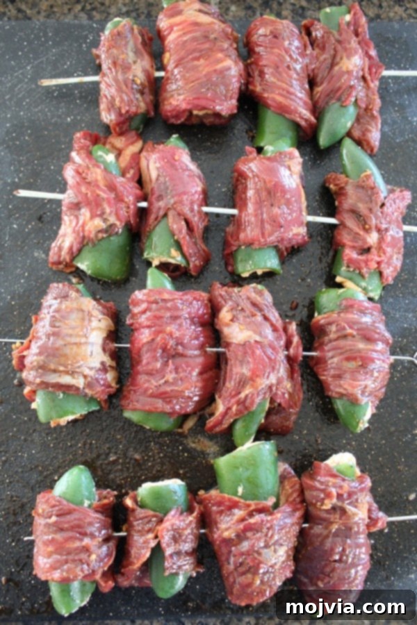 Smoky Sriracha Steak Popper Skewers 13 Four steak wrapped jalapeño poppers threaded onto a skewer
