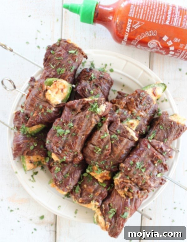 Smoky Sriracha Steak Popper Skewers 14 Sriracha Steak Wrapped Jalapeño Poppers grilling on an outdoor grill