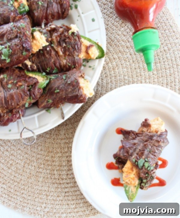 Smoky Sriracha Steak Popper Skewers 15 Grilled Sriracha Steak Wrapped Jalapeño Popper Skewers on a wooden board
