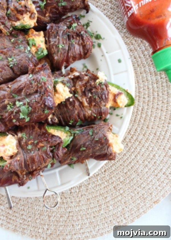 Smoky Sriracha Steak Popper Skewers 5 Sriracha Steak Wrapped Jalapeño Popper Skewers on a serving platter
