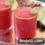 Basil Infused Strawberry Daiquiri 5 Frozen strawberry daiquiri in glass on copper tray with fresh lime wedges