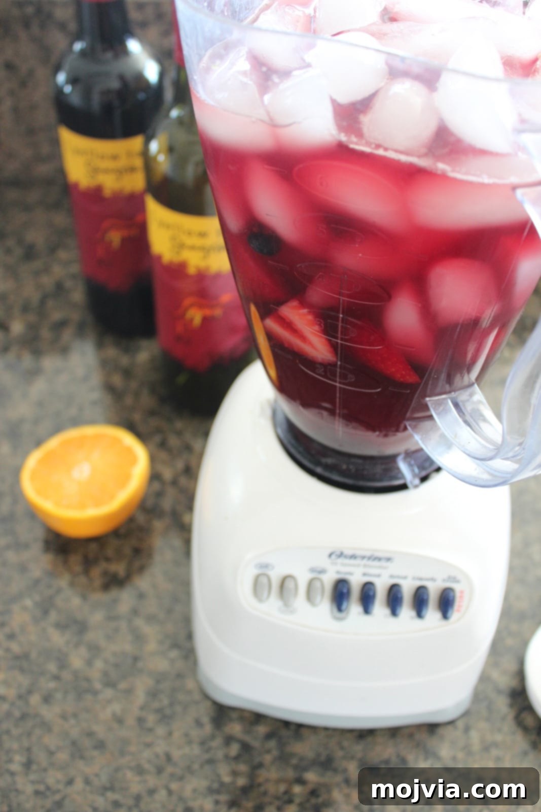 A close-up of the blender with all ingredients combined, ready to be blended into frozen sangria