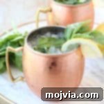 Sun-Kissed Peach Basil Mule 5 Copper mugs with moscow mules with fresh basil and lemon wedges