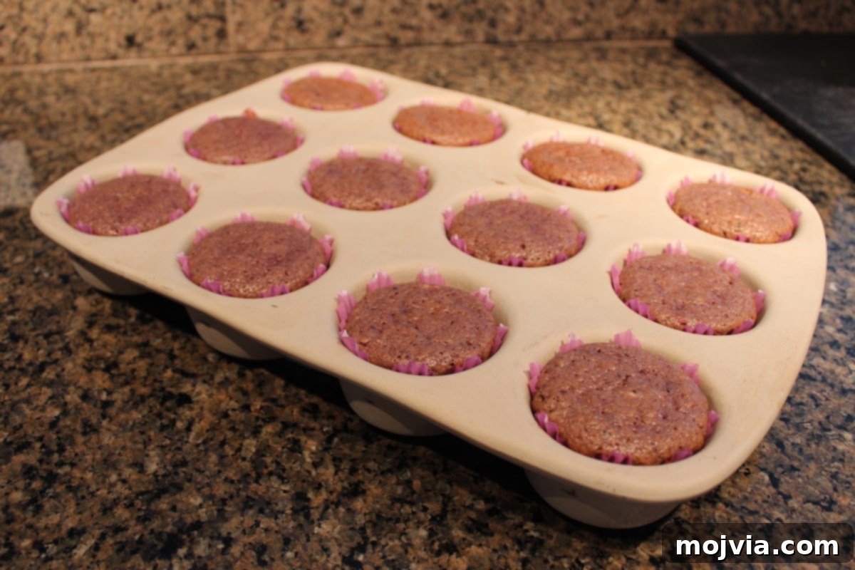 Zesty Strawberry Kiwi Cupcakes 8 Baked Strawberry Kiwi Cupcakes cooling in a muffin pan