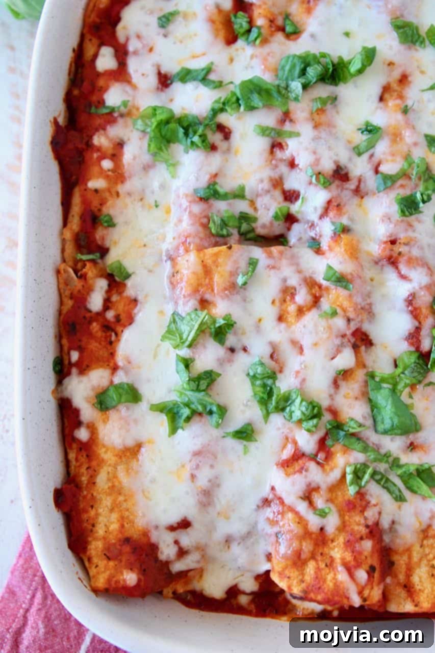 Overhead image of Italian enchiladas in baking dish topped with chopped fresh basil