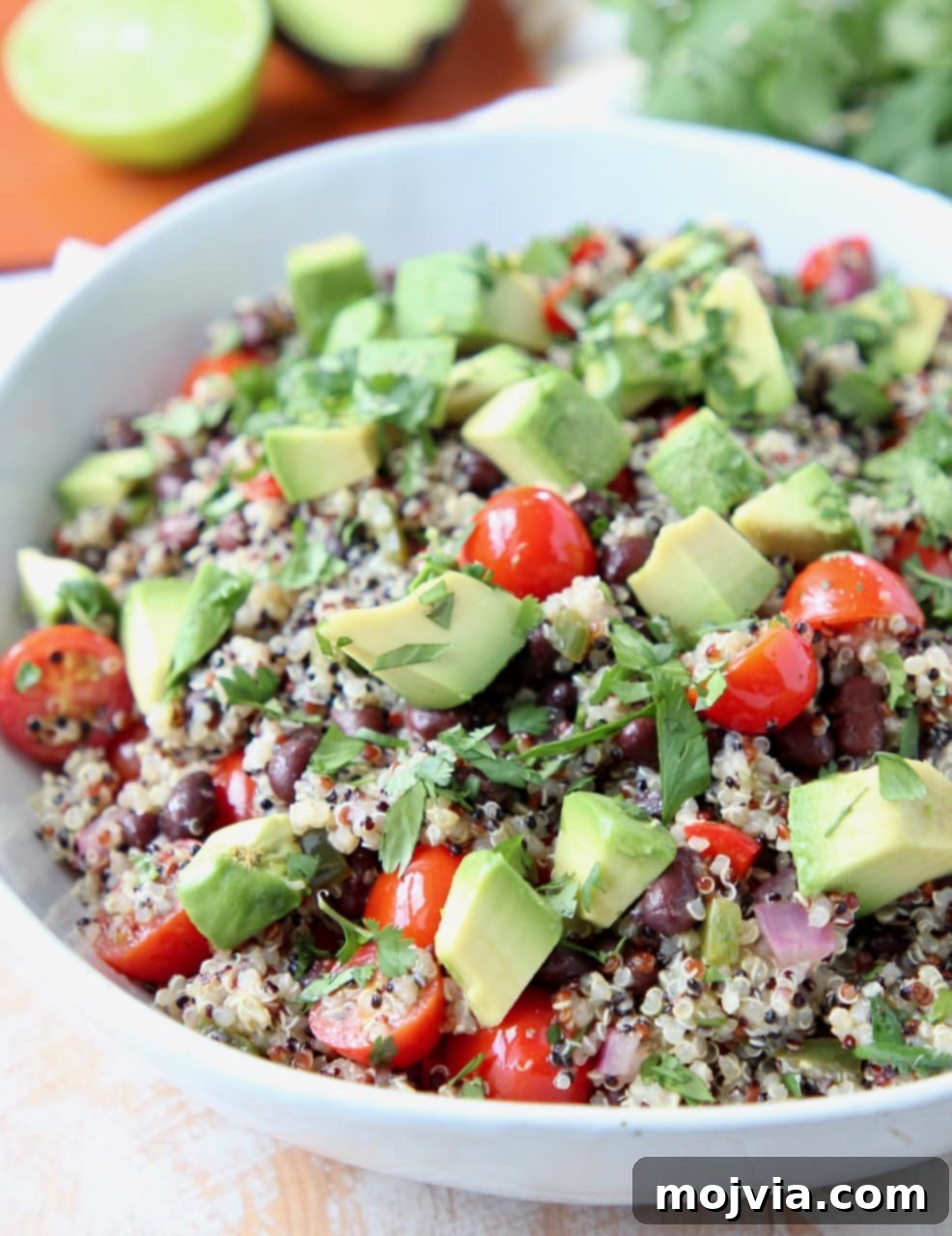 Fiesta Quinoa Salad 4 Quinoa salad in white bowl topped with diced avocado and cilantro