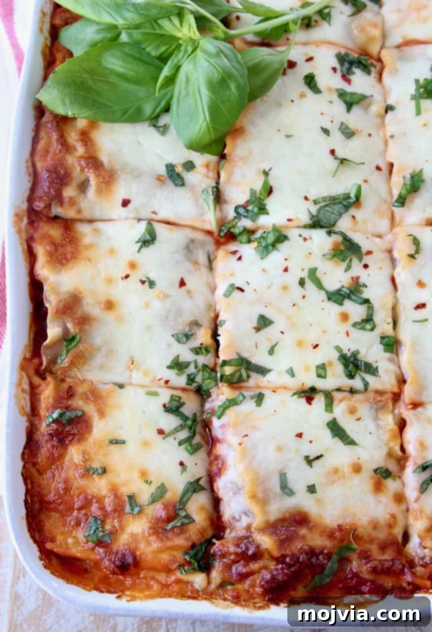Green Goodness Lasagna 2 overhead image of lasagna in white casserole dish sliced into pieces