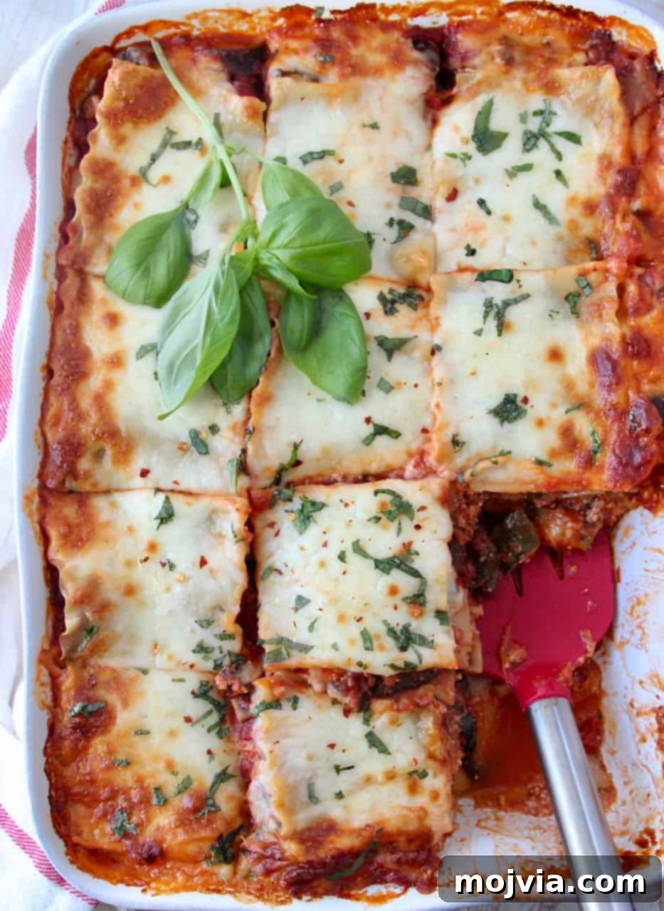 Green Goodness Lasagna 5 overhead image of lasagna in casserole dish cut into squares with red spatula