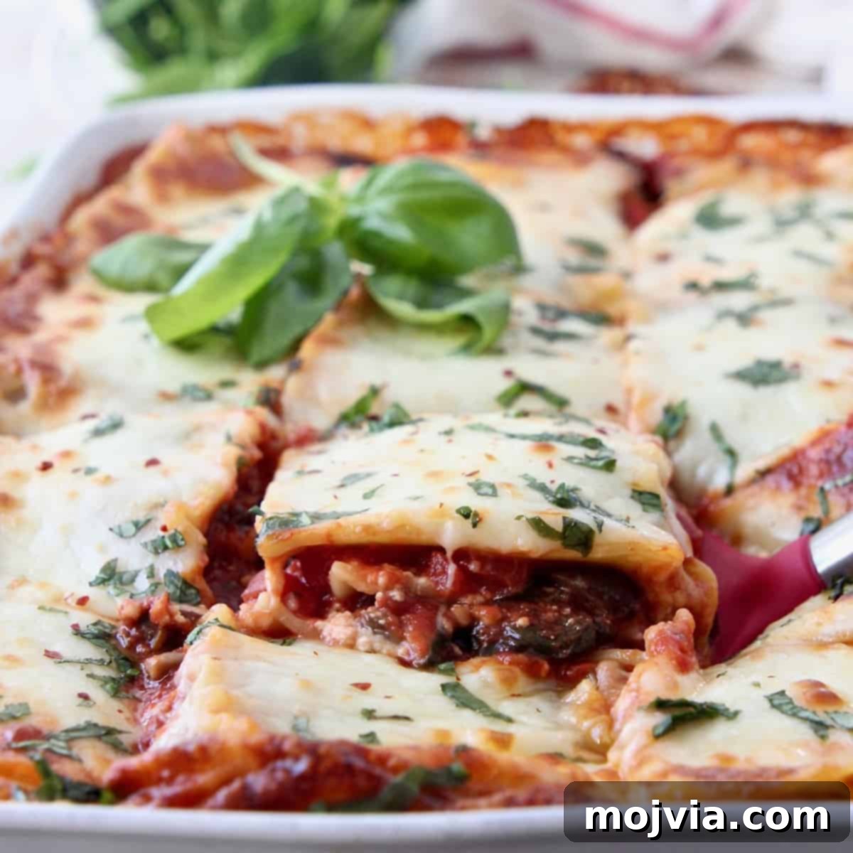 Green Goodness Lasagna 6 slice of vegetable lasagna being lifted out of casserole dish