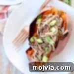 Pulled pork stuffed in roasted sweet potato on plate with fork