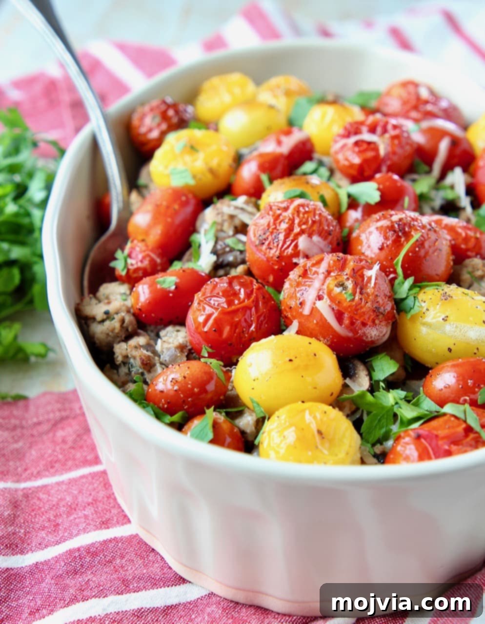 Italian Turkey Polenta Bake 3 Close-up of Ground turkey casserole topped with vibrant heirloom cherry tomatoes and fresh chopped parsley, showcasing its appetizing layers.