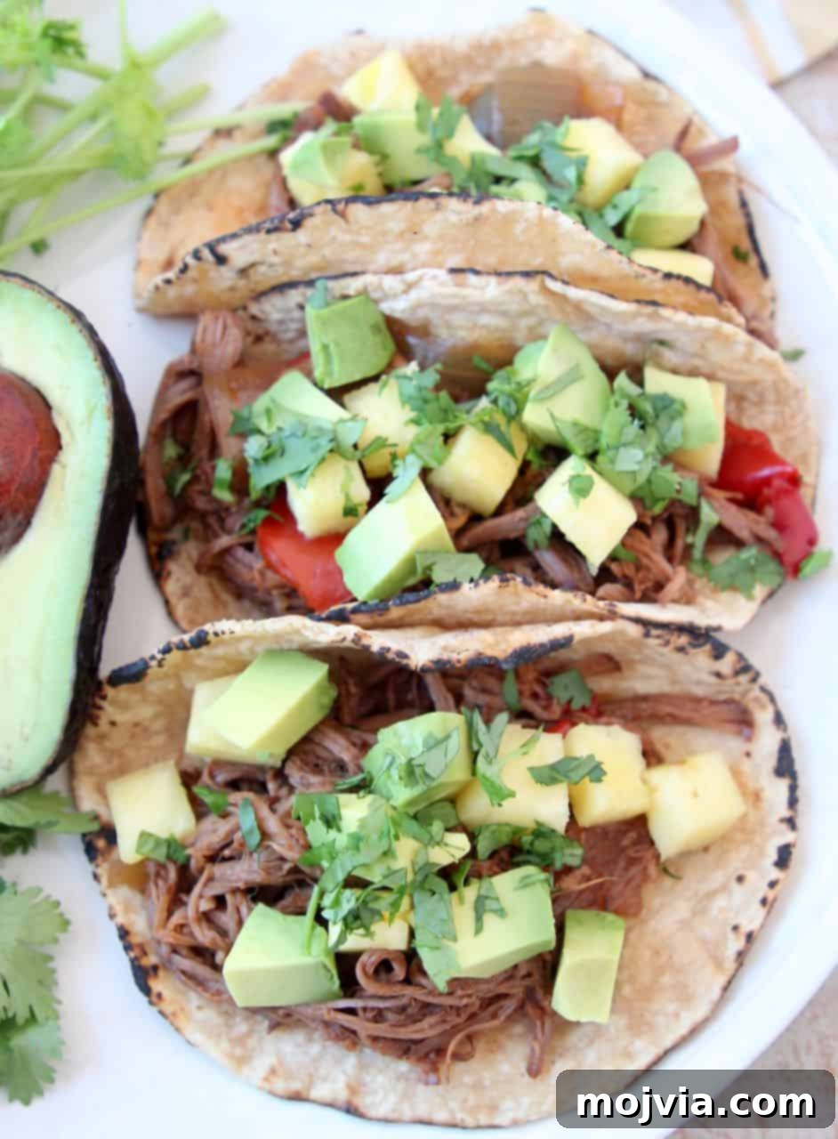 Crockpot Pulled Beef Tacos 5 Three shredded tri tip tacos on plate with avocado