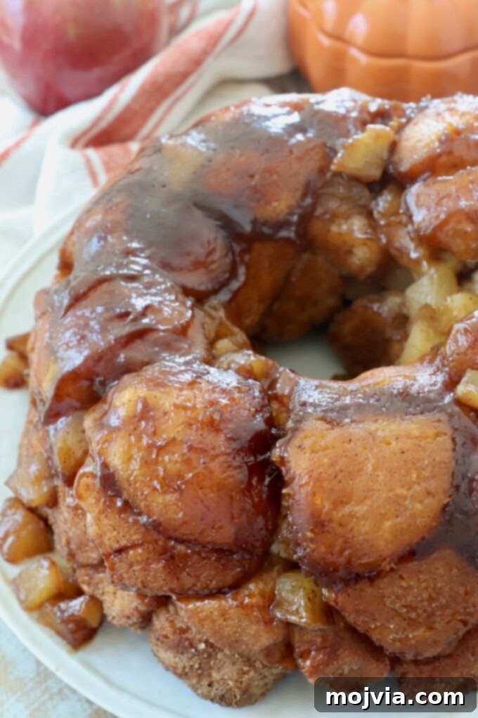 Pumpkin apple monkey bread inverted onto a plate, showcasing its beautiful, sticky caramelized exterior.