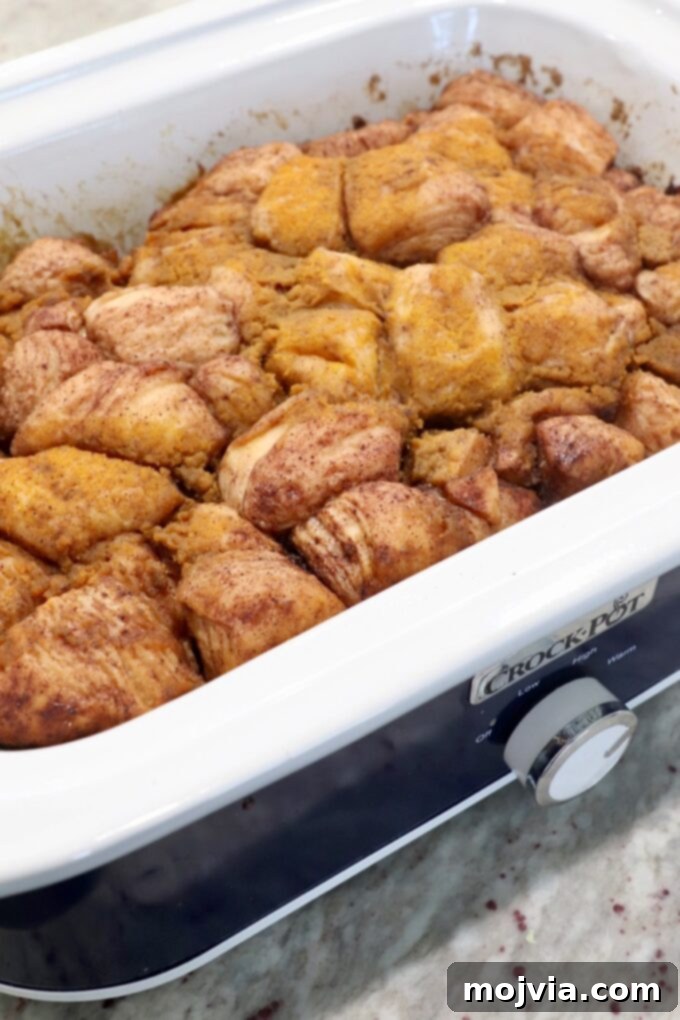 Cooked pumpkin apple monkey bread served warm directly from the Crock Pot, showing its gooey texture.