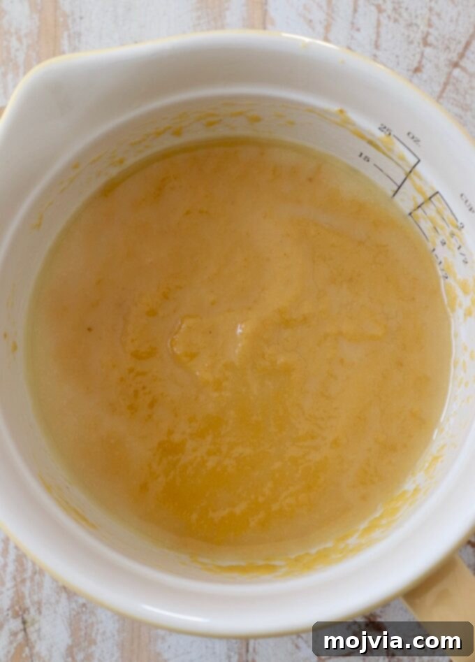 Pumpkin puree and melted butter mixed together in a bowl, creating the delicious sauce for monkey bread.