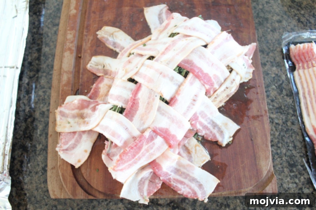 Golden Bacon Wrapped Turkey Breast 7 A beautiful bacon weave skillfully placed on top of the turkey breast on a wooden cutting board.