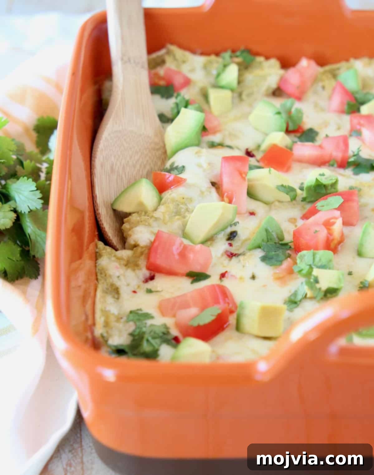 Cheesy Chicken Enchilada Bake 2 Vibrant Chicken Enchilada Casserole baking in an orange dish, ready to be served