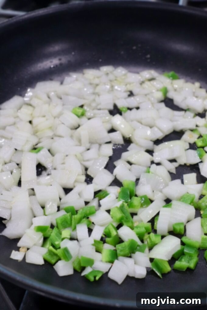 Homestyle White Chicken Chili 4 Diced onions and jalapeños sautéing in a skillet