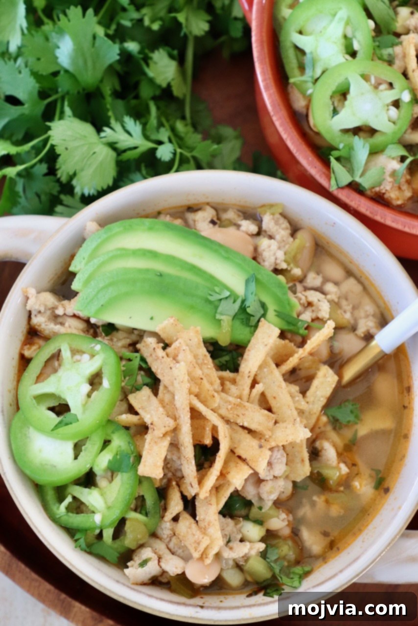 Homestyle White Chicken Chili 8 Bowls of white chicken chili topped with generous amounts of sliced jalapeños, avocado, and crispy tortilla strips