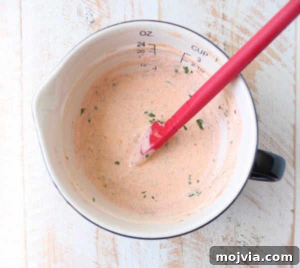 Buffalo Kick Potato Salad 5 creamy buffalo sauce dressing in a bowl with a red spatula