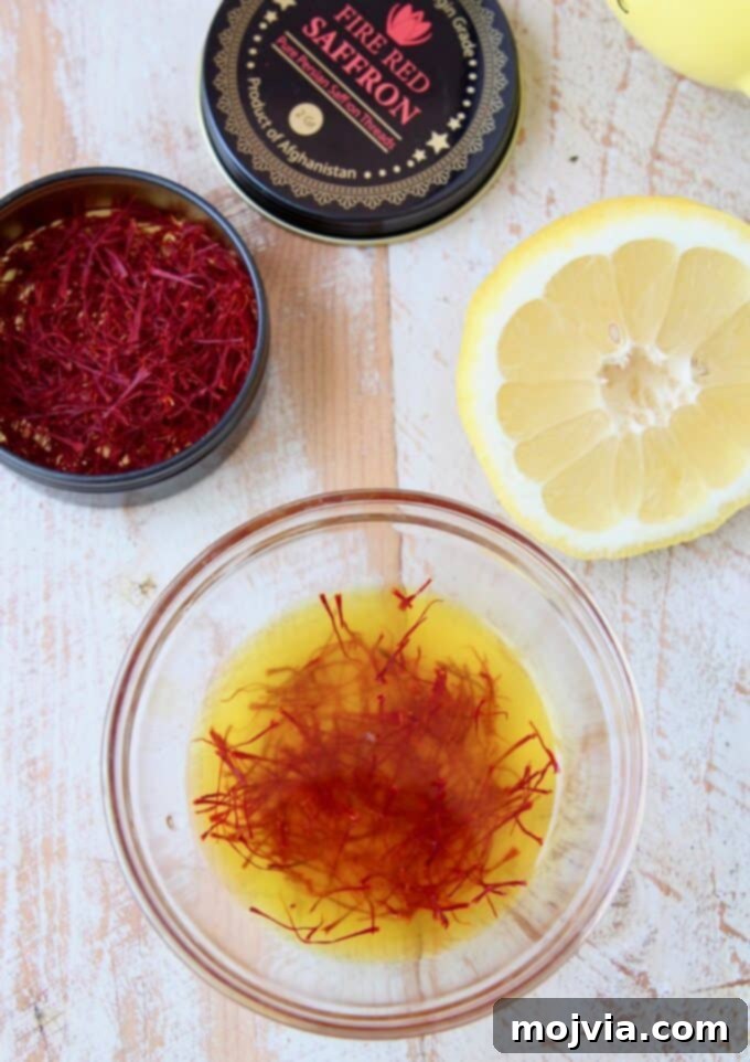 Saffron threads soaking in lemon juice in a small white bowl, showing the deep red threads beginning to release their color.