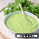 Zesty Cilantro Pesto 5 Cilantro pesto in white bowl with gold spoon