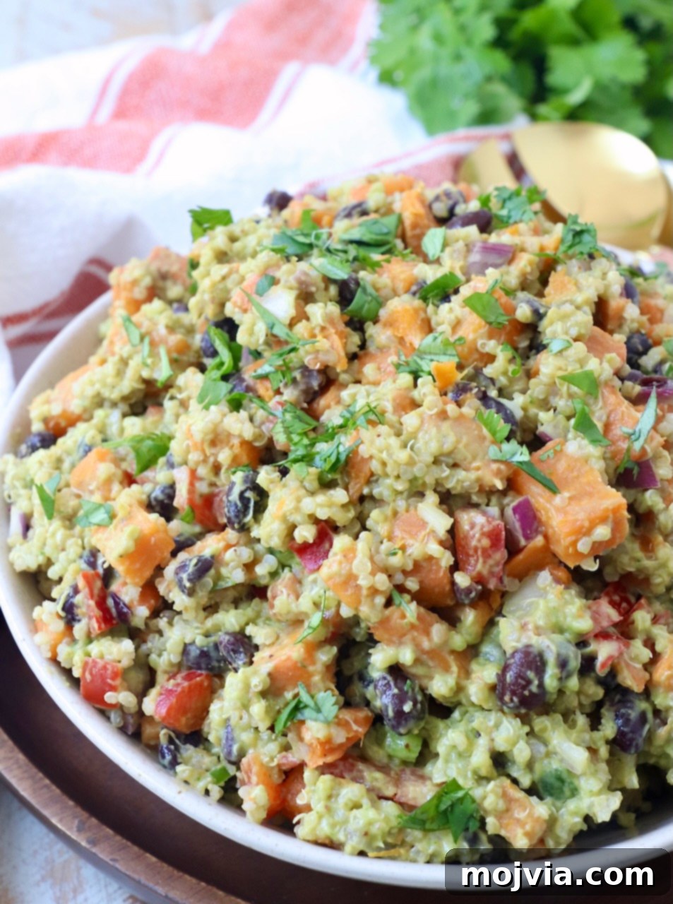 Fiesta Sweet Potato Salad 2 A bowl of vibrant Mexican Sweet Potato Salad, showcasing sweet potatoes, quinoa, black beans, and avocado dressing.