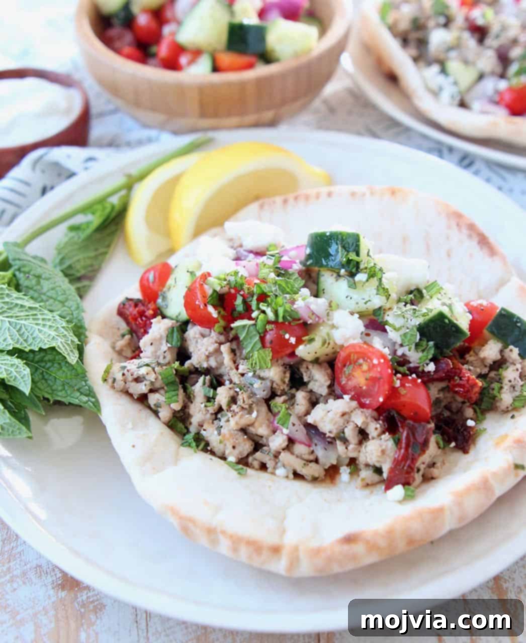 Mediterranean Turkey Gyros 2 Delicious ground turkey gyro served on a plate with fresh cucumber tomato salsa, ready to eat.