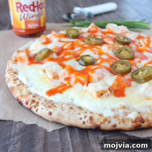 Loaded Buffalo Chicken Pizza 2 A mouth-watering Buffalo Chicken Dip Pizza slice being served, showcasing melted cheese, tender chicken, and vibrant buffalo sauce.