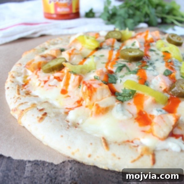 Loaded Buffalo Chicken Pizza 8 A fully cooked Buffalo Chicken Dip Pizza, topped with melted cheese, chicken, buffalo sauce, pepperoncinis, and jalapeños, ready to be sliced.