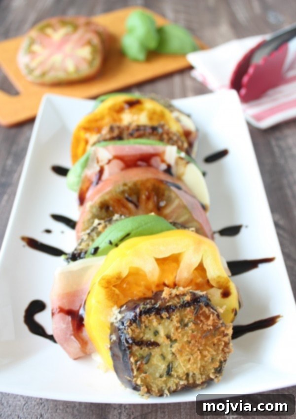 Elevated Caprese with Crispy Eggplant and Prosciutto 7 Crispy Eggplant & Prosciutto Caprese Salad on a white plate.