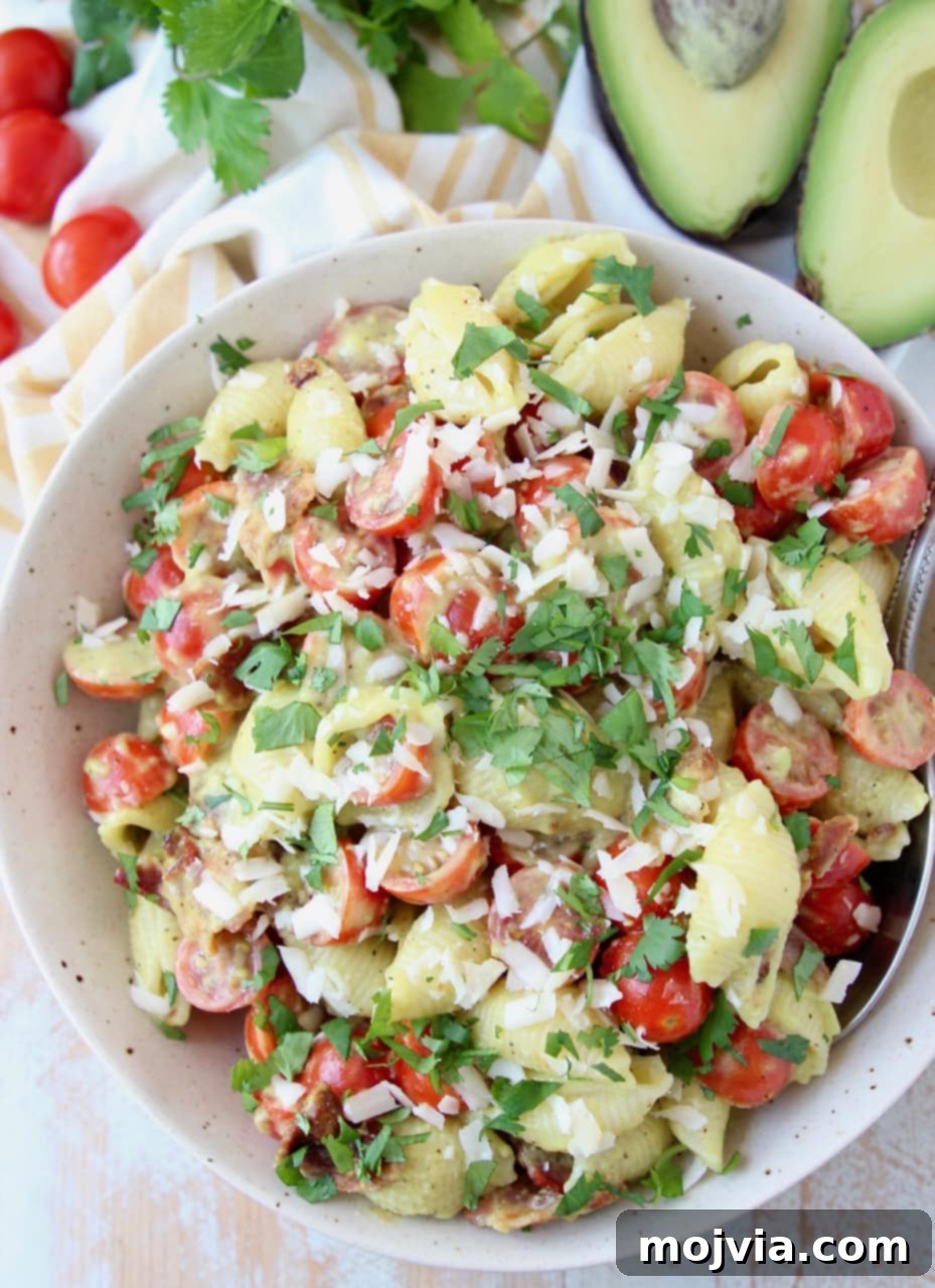 Blissful Bacon Avocado Pasta Salad 3 Overhead shot of BLT pasta salad in a bowl, topped with parmesan cheese and fresh basil