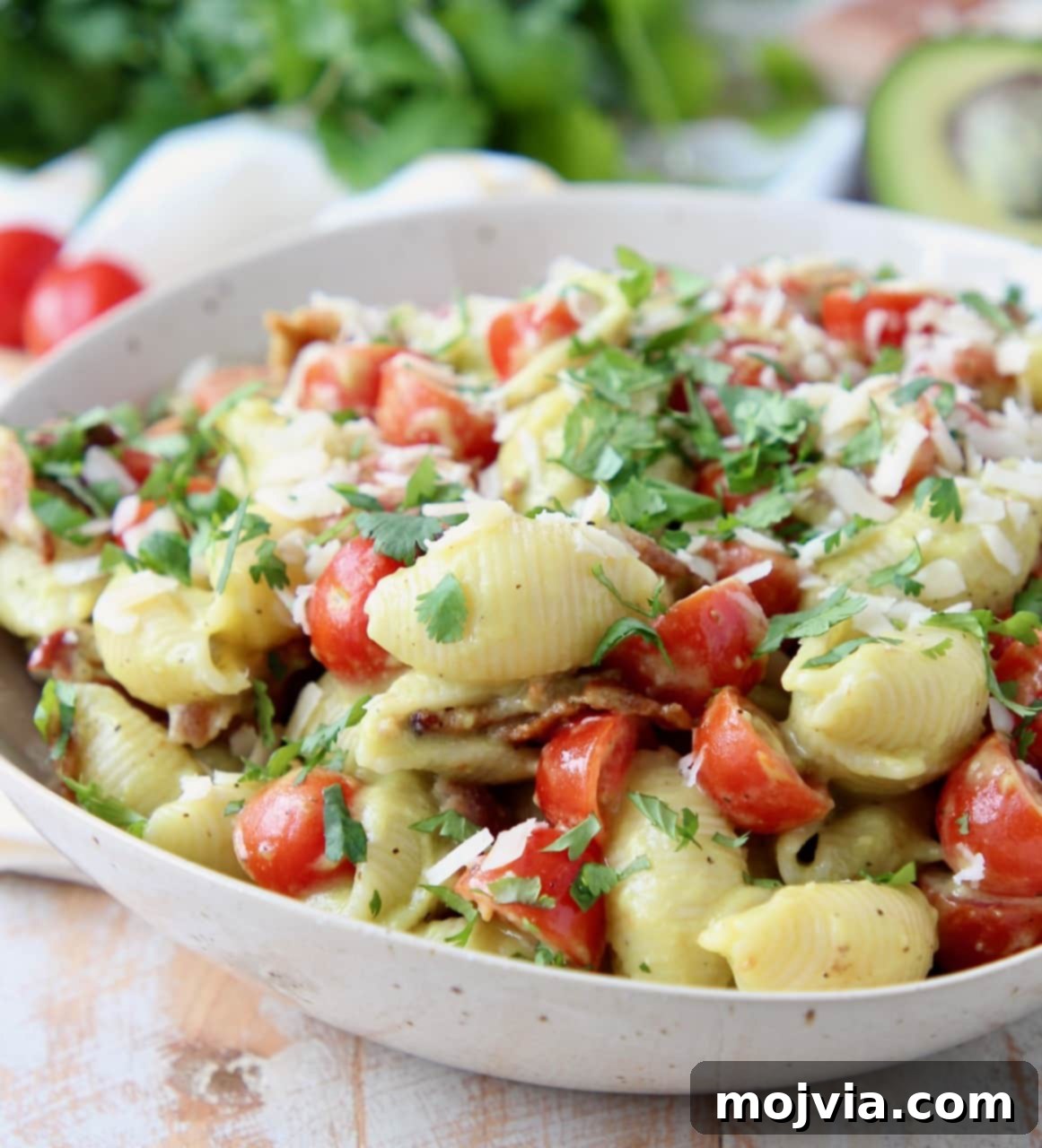 Blissful Bacon Avocado Pasta Salad 4 Pasta salad in bowl with diced tomatoes and bacon