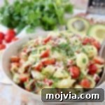 Blissful Bacon Avocado Pasta Salad 5 Pasta salad in bowl with sliced cherry tomatoes