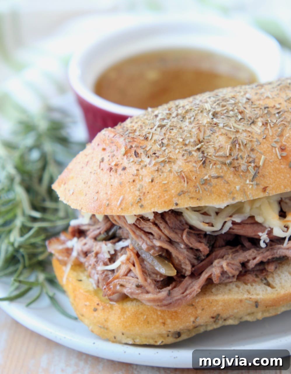 Shredded tri tip sandwich on plate with fresh rosemary