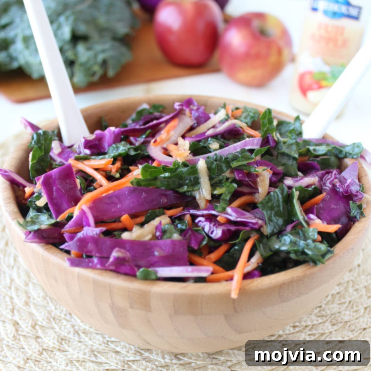 Crisp Kale and Apple Slaw 2 Freshly prepared Kale Apple Slaw in a rustic wood bowl, ready to be served.