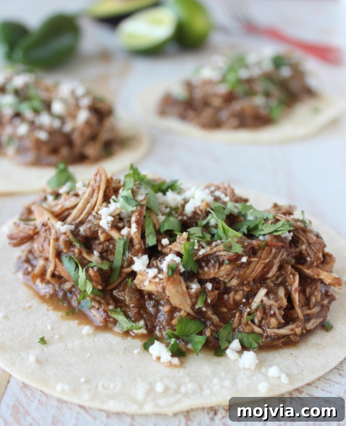 Deeply Flavorful Slow Cooker Chicken Mole 2 Shredded chicken in a rich mole sauce, garnished with fresh cilantro on a warm tortilla, ready to be served as a taco.