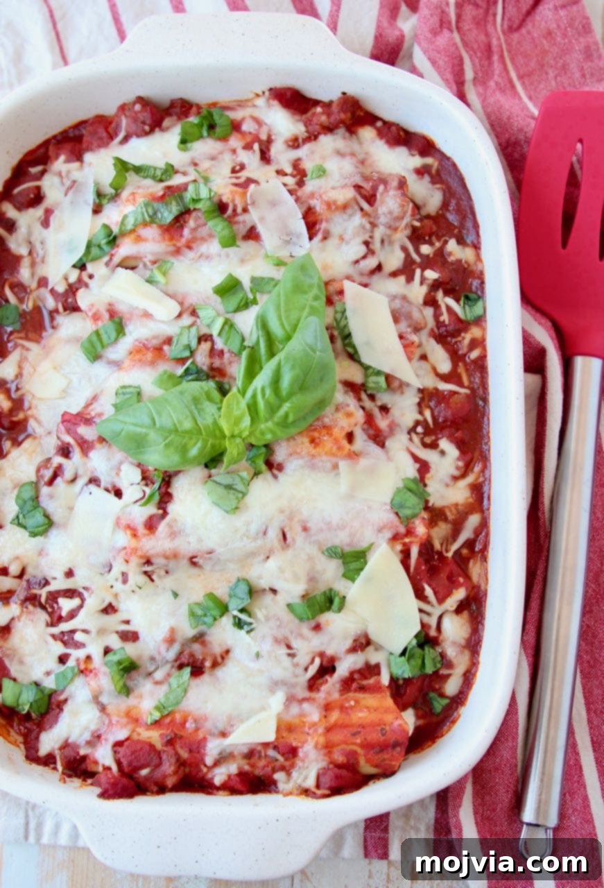 Hearty Three-Cheese Manicotti with Robust Italian Sausage Marinara 2 Baked manicotti in casserole dish topped with fresh basil leaves, ready to be served.
