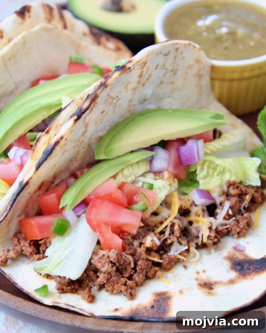 Trader Joe's Twist on Tacos 2 Delicious ground beef tacos with fresh avocado slices and diced tomatoes, ready to eat