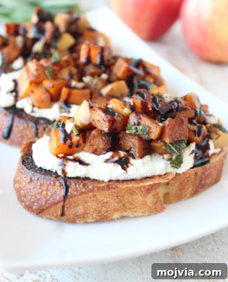 Caramelized Butternut Apple Crostini 7 diced butternut squash and apples on top of ricotta cheese on toasted slices of bread on plate