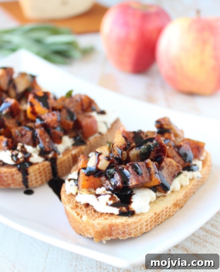 Caramelized Butternut Apple Crostini 8 roasted diced butternut squash on top of ricotta cheese on sliced bread, drizzled with balsamic glaze, on white plate