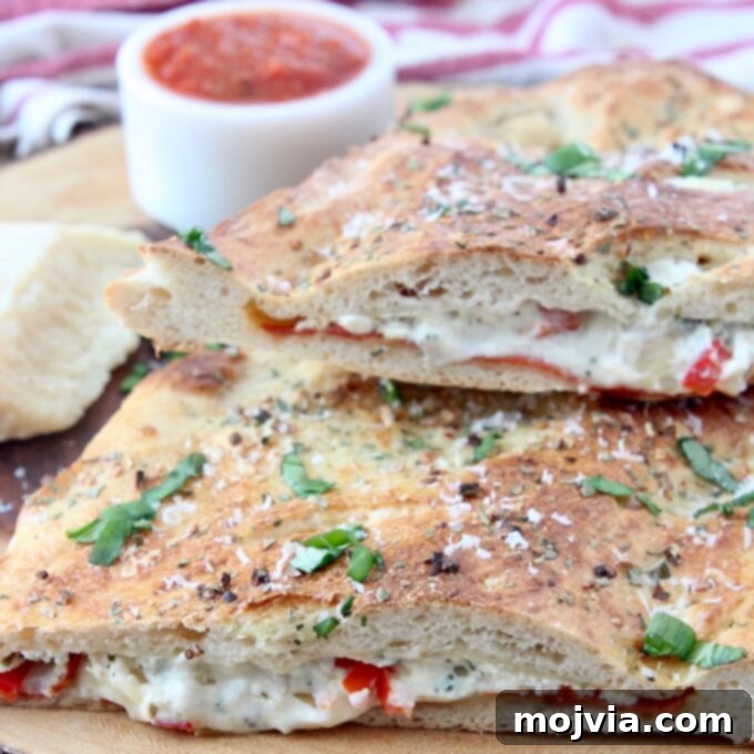 A perfectly baked calzone, cut in half to reveal its cheesy, savory filling, resting on a rustic wooden cutting board, ready to be enjoyed.