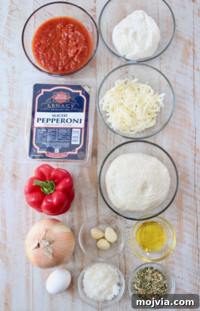 A vibrant flat lay of all the fresh ingredients required to make a homemade calzone, including pizza dough, various cheeses, bell peppers, onion, garlic, pepperoni, and seasonings.