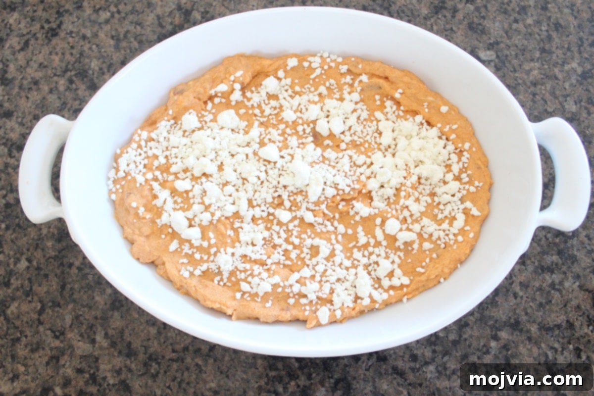 Baked Sweet Potato and Three Cheese Dip topped with crumbled goat cheese, ready for the oven.