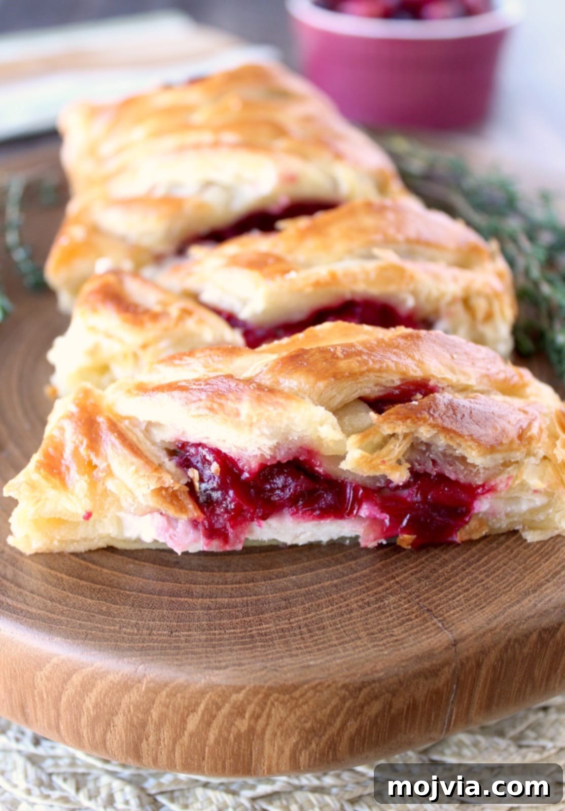 Golden Cranberry Turkey Puffs 2 Golden-brown Cranberry Turkey Puff Pastry filled with creamy turkey and cranberry relish, ready to be served on a white platter.