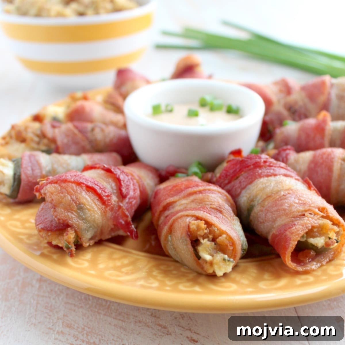 Explosive Cream Cheese Jalapeno Bites 9 Baked bacon wrapped jalapeno poppers on a wire rack.