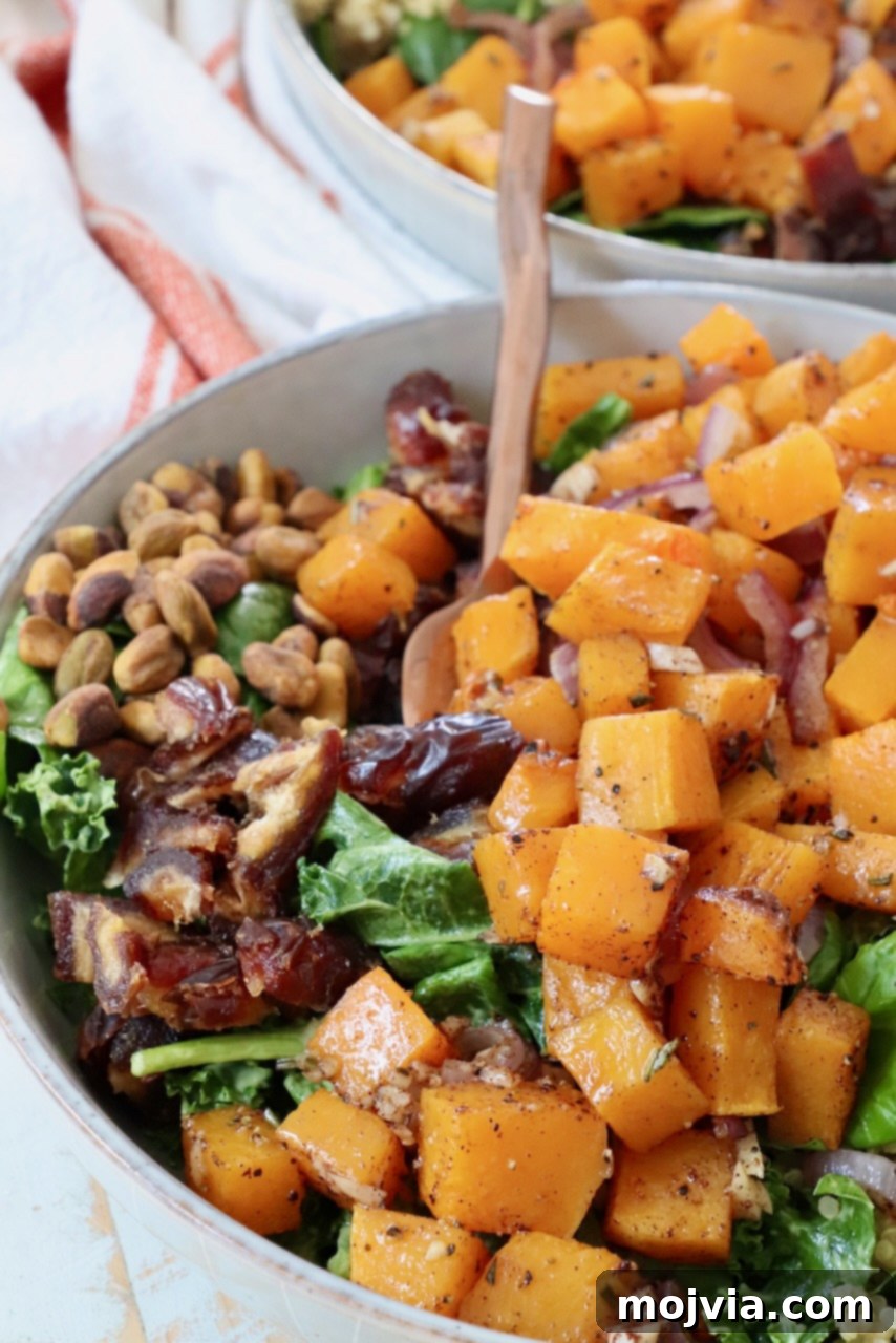Golden Roasted Butternut Salad 2 roasted diced butternut squash on top of a salad in a bowl
