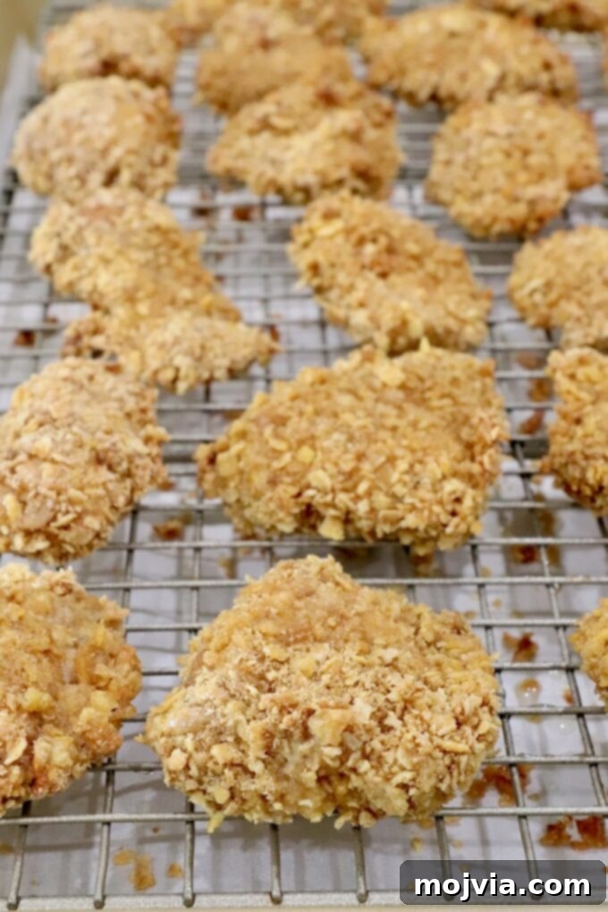 Sweet Heat Chipotle Chicken Tenders 12 Cooked, golden-brown breaded chicken pieces on a wire rack after baking.