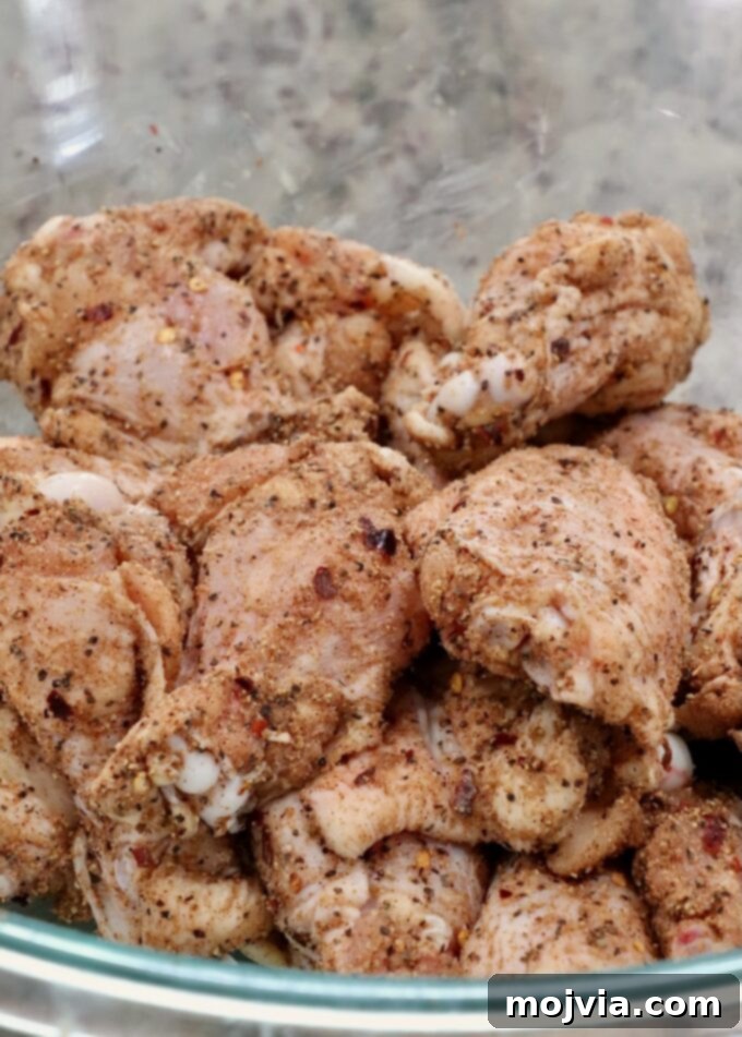 seasoned raw chicken wings in a glass bowl